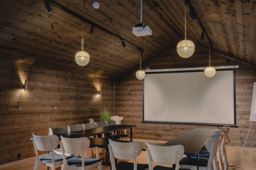 Møterommet har stor takhøyde – men er alt annet enn et kaldt konferanserom. Her er rommet kledd i Karatpanel i fargen Moskus.