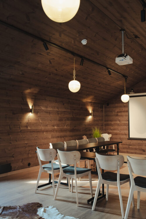 Møterommet har stor takhøyde – men er alt annet enn et kaldt konferanserom. Her er rommet kledd i Karatpanel i fargen Moskus.